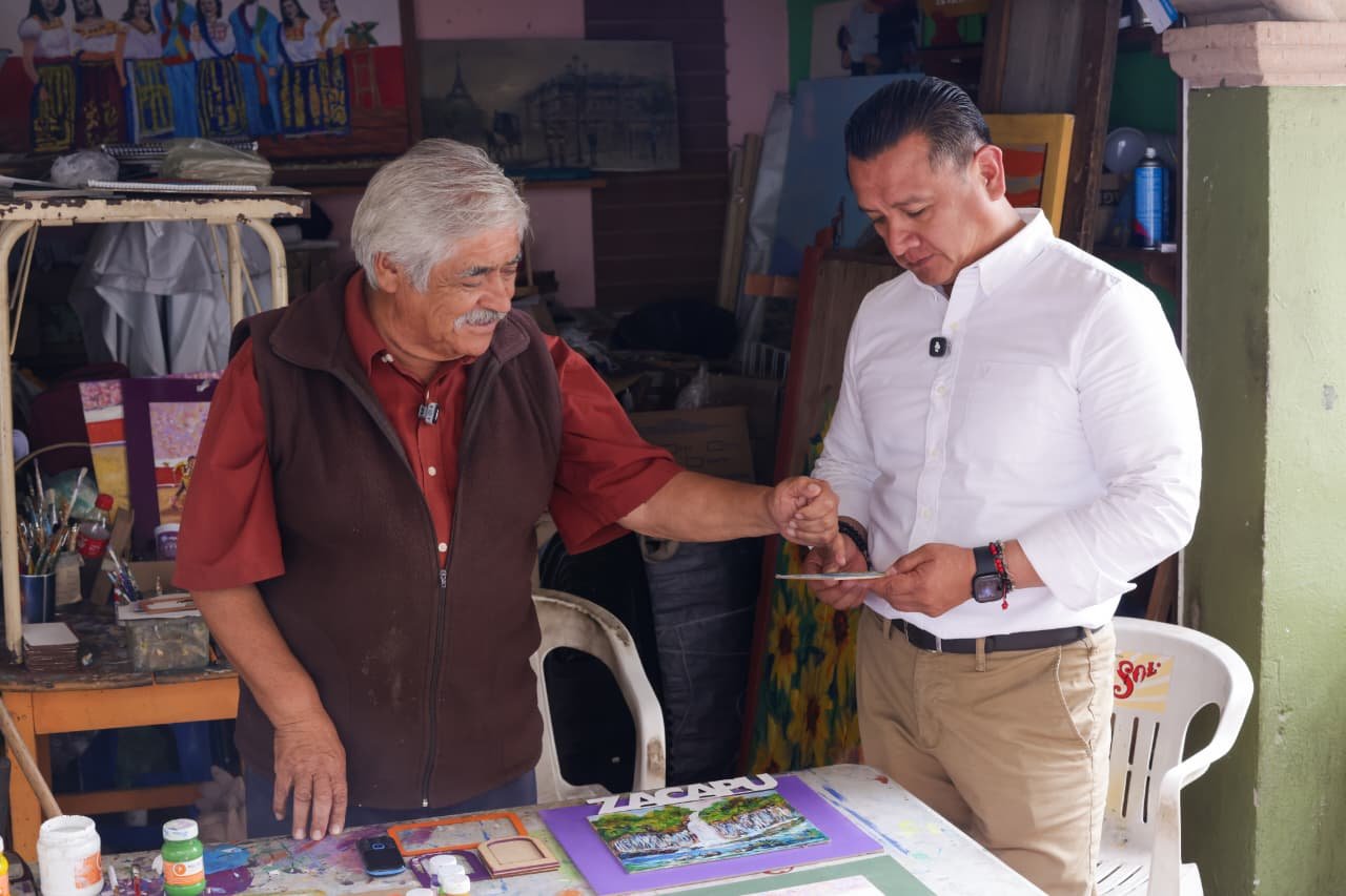 Carlos Torres Piña caminando entre ciudadanos en una comunidad rural de Michoacán, en interacción cercana y sin cámaras visibles