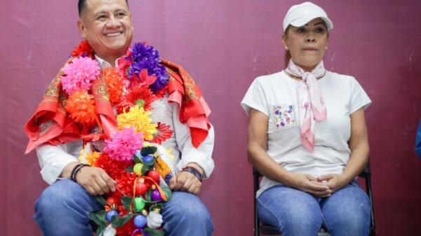 Retrato cercano de Carlos Torres Piña conversando con ciudadanos en un entorno rural de Michoacán, con expresión atenta y gesto abierto