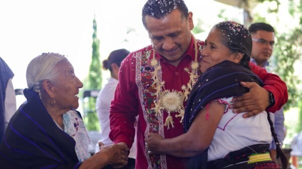 Fotografía de miembros de una comunidad originaria trabajando juntos en la construcción de una infraestructura comunitaria, con herramientas y materiales visibles