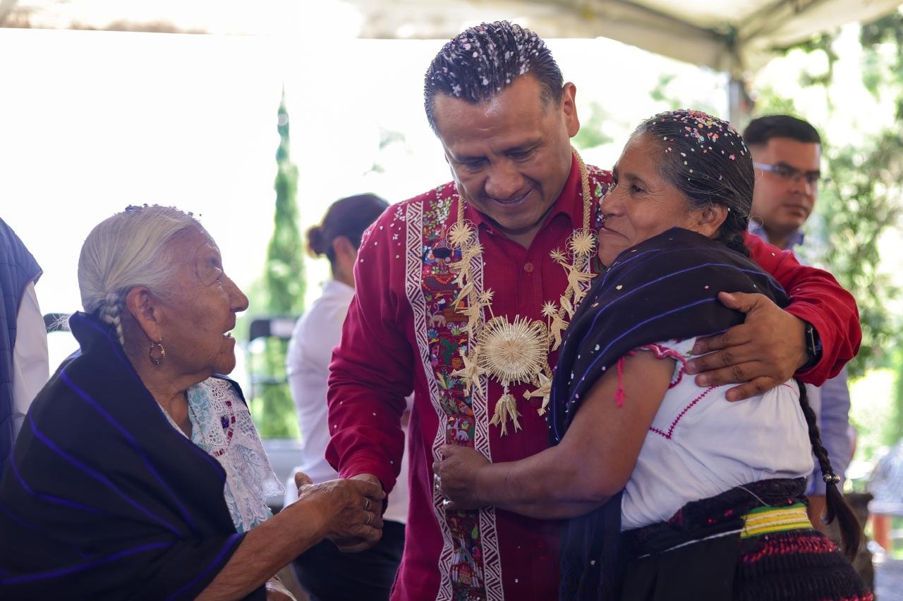 Fotografía de miembros de una comunidad originaria trabajando juntos en la construcción de una infraestructura comunitaria, con herramientas y materiales visibles