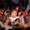 Carlos Torres Piña conversando con artesanos locales frente a talleres de sillas de madera en Maravatío, Michoacán