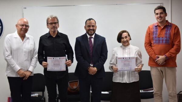 Evento formativo de la Fiscalía General de Michoacán con participantes presenciales y pantallas virtuales, bajo el lema 'Un nuevo humanismo al servicio de la justicia'.