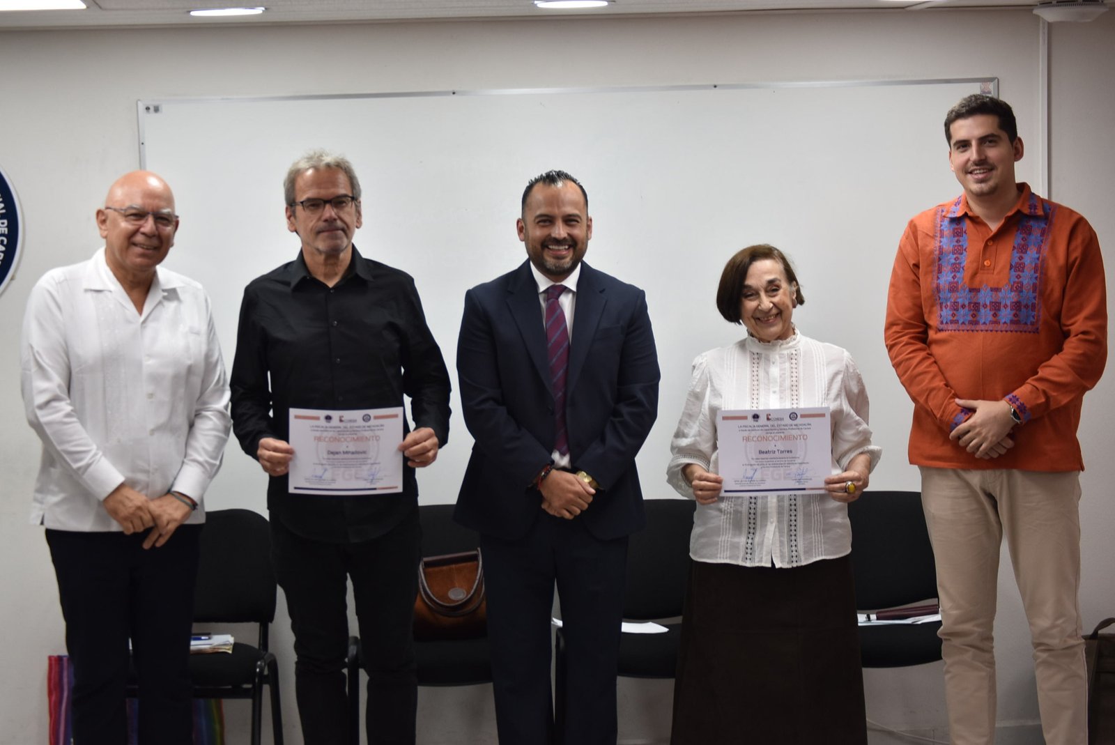 Evento formativo de la Fiscalía General de Michoacán con participantes presenciales y pantallas virtuales, bajo el lema 'Un nuevo humanismo al servicio de la justicia'.