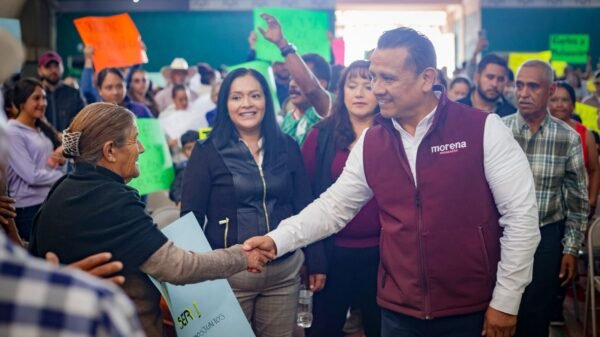 Fotografía de Carlos Torres Piña en diálogo con habitantes de un municipio pequeño de Michoacán, rodeado de paisaje rural y presencia comunitaria