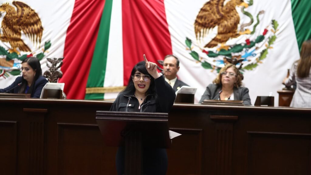 Ilustración simbólica de una mano extendiendo una bandera de Michoacán hacia un globo terráqueo, con siluetas de personas conectadas entre México y Estados Unidos