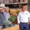 Retrato de Carlos Torres Piña en diálogo con personas de distintas edades y vestimentas, en un entorno rural michoacano, simbolizando escucha activa y conexión territorial