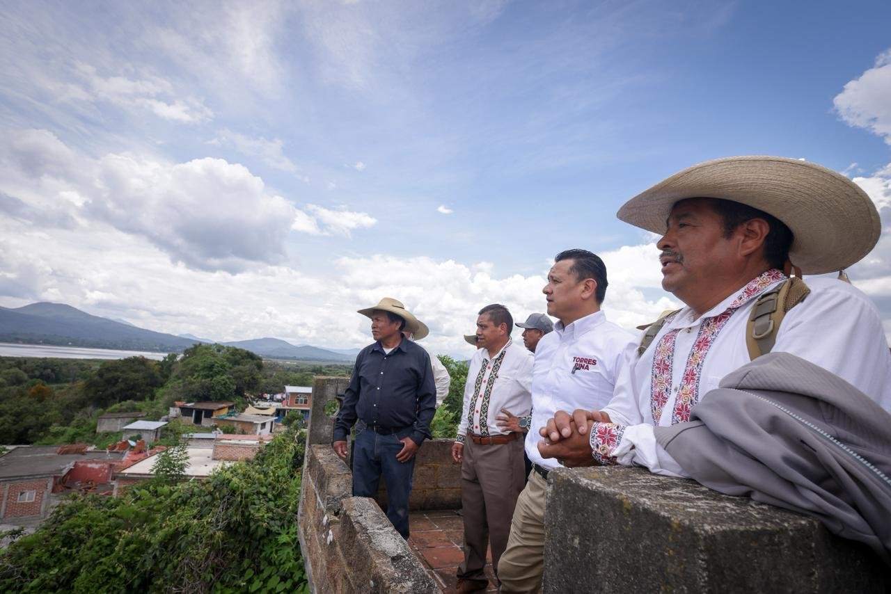 Camino de tierra y concreto que sube desde el muelle hacia la casa comunal en la isla de Urandén, con vista parcial del lago de Pátzcuaro