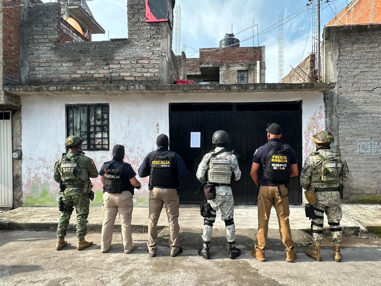 Operativo policial en fachada de vivienda en colonia Primo Tapia Oriente, Morelia, con presencia de agentes de la FGE y evidencia de cateo