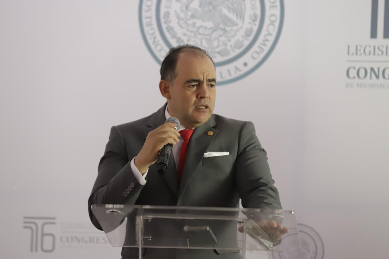Fotografía de diputado Baltazar Gaona García hablando ante micrófono en el Congreso del Estado de Michoacán, con logo de la Suprema Corte visible en fondo