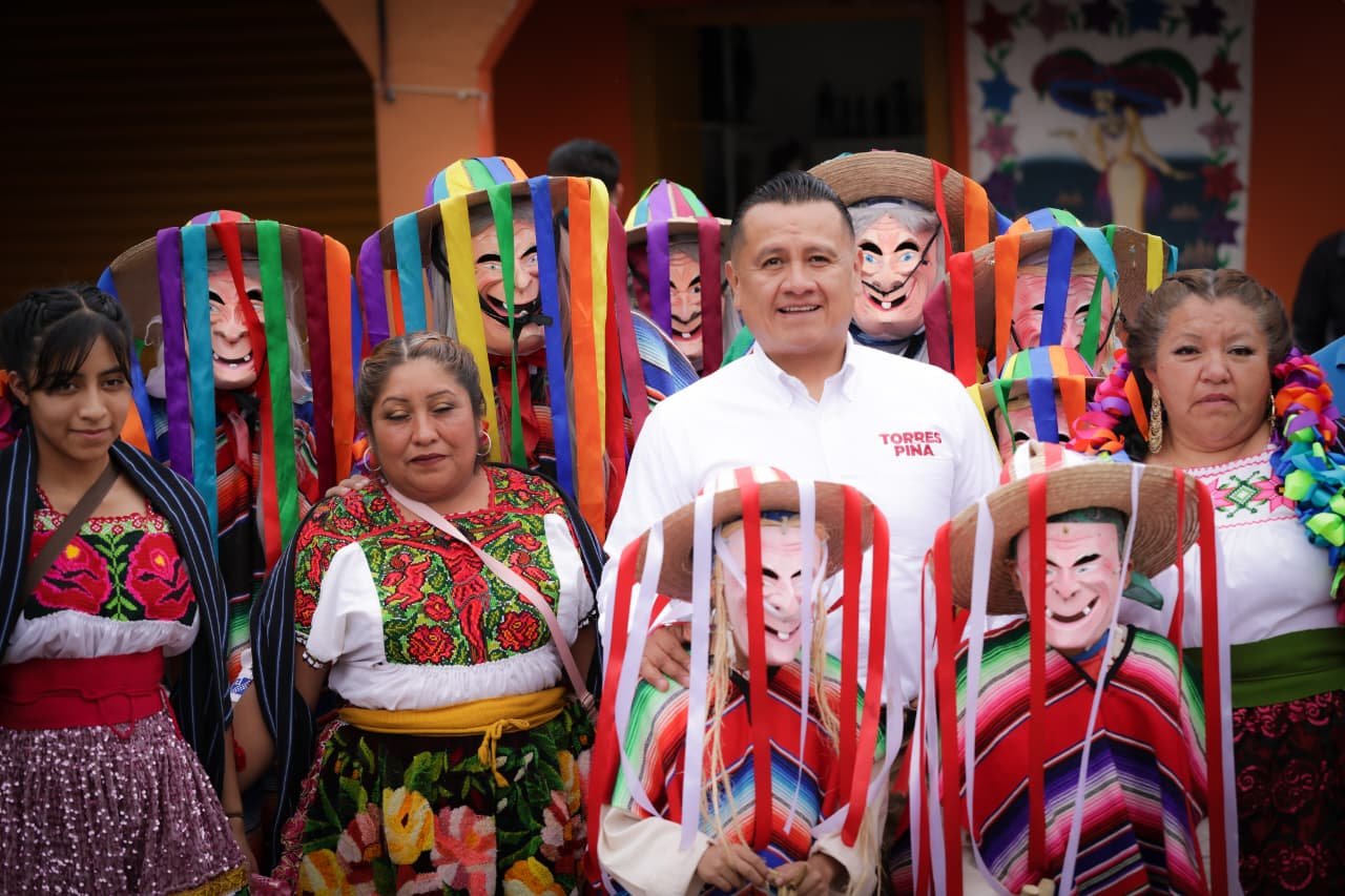 Carlos Torres Piña conversando con comuneros en Urandén, Michoacán, frente a un camino recién construido con apoyo de