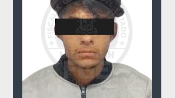 Fiscalía Michoacán detención: imagen simbólica de una balanza y un escudo institucional con fondo de Zamora, Michoacán