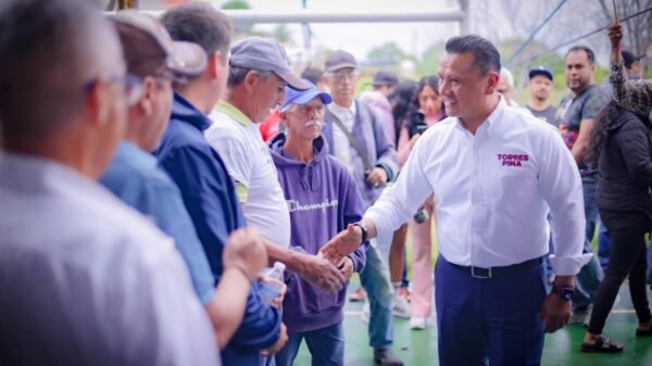 Fotografía de Carlos Torres Piña en reunión con comuneros y productores en una comunidad rural de Michoacán, destacando su