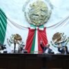 Grupo de artesanos michoacanos trabajando en talleres tradicionales, con símbolos de protección legal y apoyo institucional