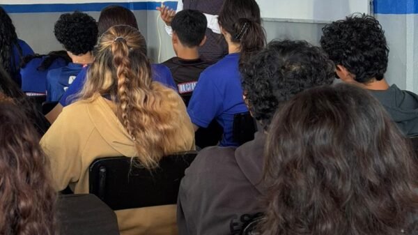 Grupo de estudiantes escuchando una charla sobre prevención del acoso escolar en un aula de la Universidad Sor Juana Inés de