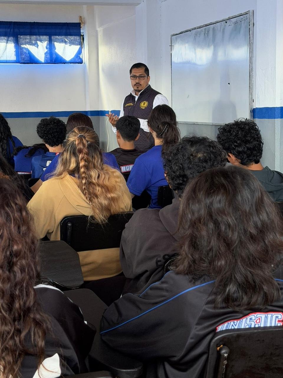 Grupo de estudiantes escuchando una charla sobre prevención del acoso escolar en un aula de la Universidad Sor Juana Inés de