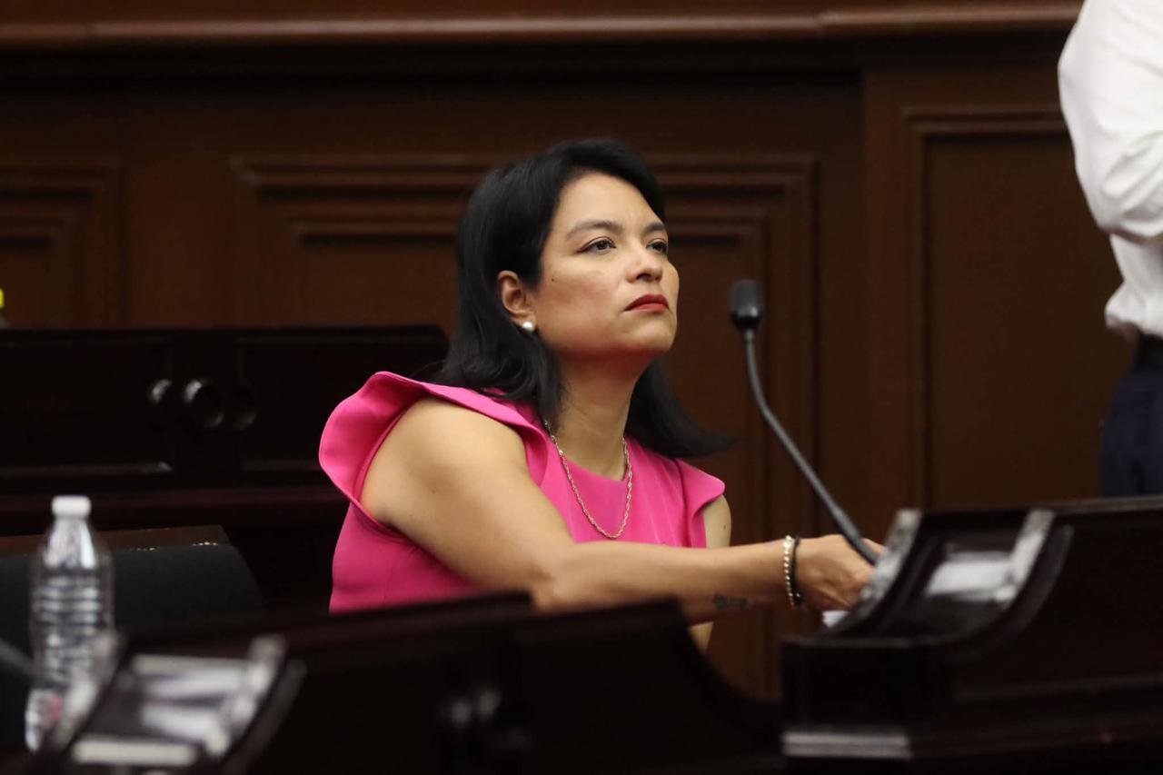 Diputada Eréndira Isauro Hernández y artesanas michoacanas frente a piezas de cerámica y textil, simbolizando familias