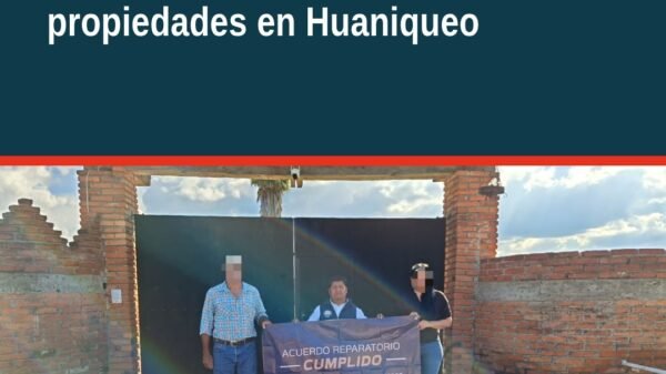 Mujer recibiendo documento de restitución de propiedades en Huaniqueo, Michoacán
