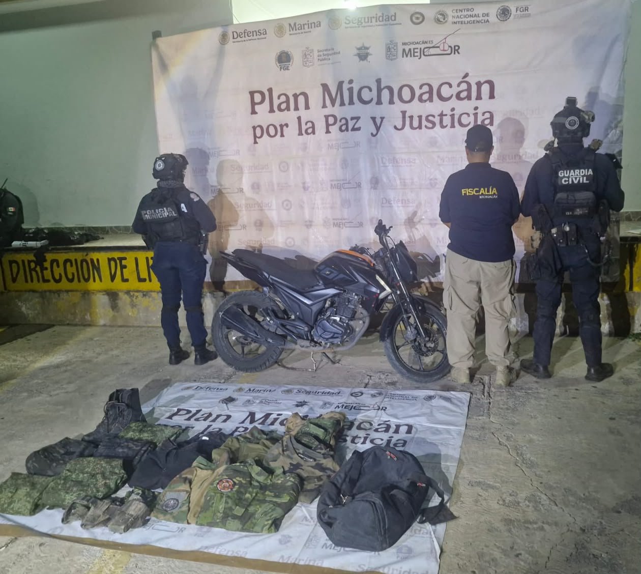 Motocicleta Italika Z200 negra con naranja y mochila con uniformes tácticos apatzingán, sobre calle Rentería Liviano